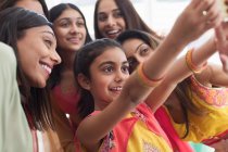 Lächelnde indische Frauen und Mädchen in Saris machen Selfie — Stockfoto
