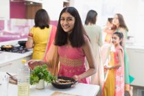 Retrato feliz chica india en sari cocina comida en la cocina - foto de stock