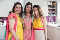 Retrato feliz hermanas indias en saris en la cocina - foto de stock