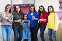 Porträt glückliche indische Frauen und Mädchen beim Essen in der Küche — Stockfoto