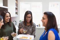 Felice donne indiane con tè e cibo in cucina — Foto stock