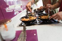 Индийские женщины готовят еду на плите на кухне — стоковое фото