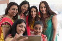 Щасливі індійські жінки і дівчата в сарі роблять селфі зі смартфоном. — стокове фото