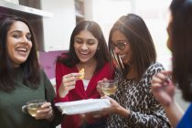 Glückliche indische Frauen essen und trinken Tee in der Küche — Stockfoto