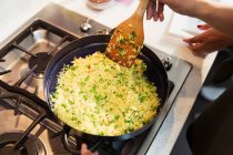 Рис і горох готують на сковороді на плиті — стокове фото