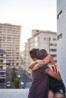 Feliz jovem casal abraçando na varanda urbana — Fotografia de Stock
