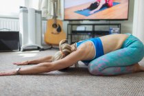 Mulher praticando ioga online em casa — Fotografia de Stock