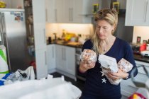 Frau lädt Lebensmittel in Küche aus — Stockfoto
