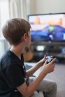 Garçon jouer jeu vidéo à la télévision — Photo de stock
