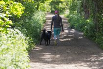 Woman walking on trail with dog — Stock Photo