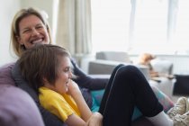 Retrato feliz madre e hijo en el sofá sala de estar - foto de stock