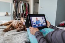 Femme vidéo bavarder avec les médecins à l'ordinateur portable de la maison — Photo de stock