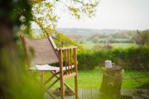 Sedia e caffè sul tranquillo balcone con vista sul campo rurale — Foto stock