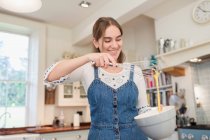 Щаслива дівчина-підліток випічка на кухні — стокове фото