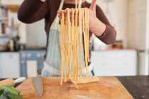 Close up donna che fa pasta fresca fatta in casa in cucina — Foto stock