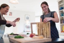 Mutter und Tochter machen frische hausgemachte Pasta in der Küche — Stockfoto