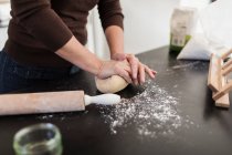 Жінка замінює тісто на кухонній лічильнику — стокове фото