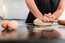 Frau knetet Teig in Großaufnahme auf Küchentisch — Stockfoto