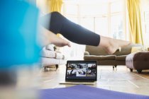Mulher se exercitando online com laptop na sala de estar — Fotografia de Stock
