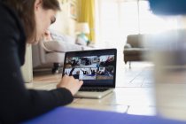 Adolescente se exercitando online na tela do laptop no chão — Fotografia de Stock