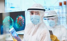 Científica mujer confiada en el retrato investigando coronavirus - foto de stock