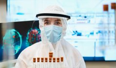 Retrato científico femenino en traje limpio estudiando la vacuna contra el coronavirus - foto de stock