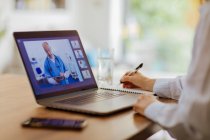 Femme vidéo bavarder avec les médecins à l'ordinateur portable de la maison — Photo de stock