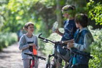 Madre e figli acqua potabile in bicicletta — Foto stock