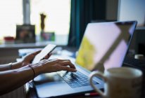 Закрыть женщину, работающую из дома на ноутбуке в домашнем офисе — стоковое фото