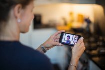 Woman video chatting with friends on smart phone screen — Stock Photo