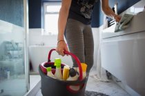 Mulher com balde de produtos de limpeza banheiro de limpeza — Fotografia de Stock