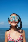 Happy girl wearing snorkel and goggles on beach — Stock Photo