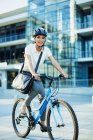 Smiling woman bike riding on urban sidewalk — Stock Photo