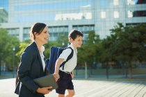 Businesswoman and son outside urban building — Stock Photo