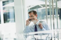 Uomo d'affari che parla al cellulare in ufficio — Foto stock