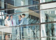 Business people talking at window — Stock Photo