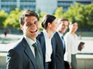 Happy businessman walking with colleagues outdoors — Stock Photo