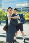 Businesswoman and son hugging in urban park — Stock Photo