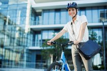 Geschäftsfrau mit Fahrrad vor städtischem Gebäude — Stockfoto