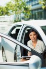 Lächelnde Geschäftsfrau sitzt im Auto — Stockfoto