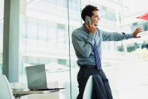 Empresário falando no celular na janela — Fotografia de Stock