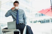 Uomo d'affari sorseggiando caffè in ufficio — Foto stock