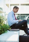 Businessman working on laptop outdoors — Stock Photo