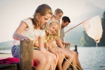 Familie mit Fischernetzen am Steg über dem See — Stockfoto