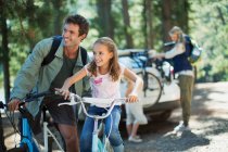 Батько і дочка на велосипедах у лісі — стокове фото