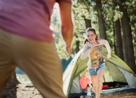 Filha correndo para o pai fora da tenda na floresta — Fotografia de Stock