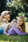 Serene mother and daughter laying in grass — Stock Photo