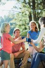 Family toasting mugs at campsite in woods — Stock Photo