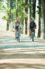 Couple riding mountain bikes in woods — Stock Photo