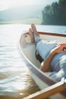 Uomo sereno posa barca a remi sul lago calmo — Foto stock